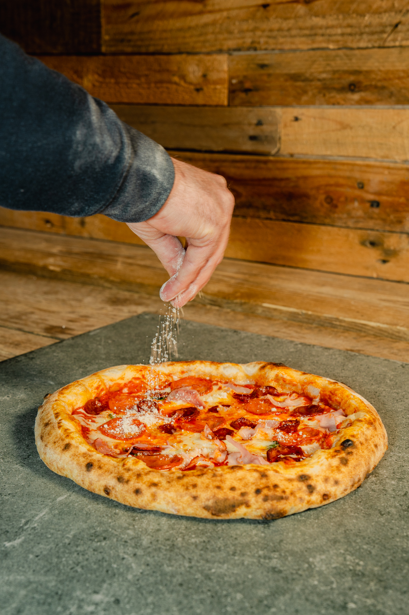 Sprinkling cheese on a pizza